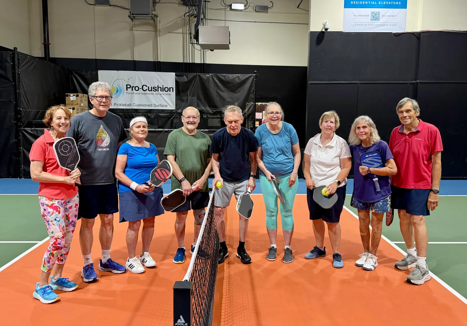 A group of P4PCT players with their paddles, standing together at the net